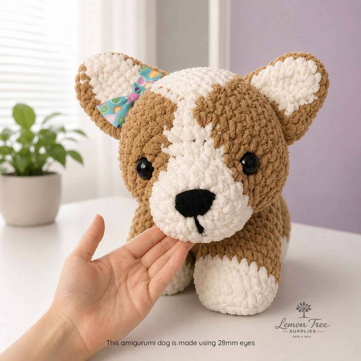 Handmade crochet dog toy held by a hand with a light background